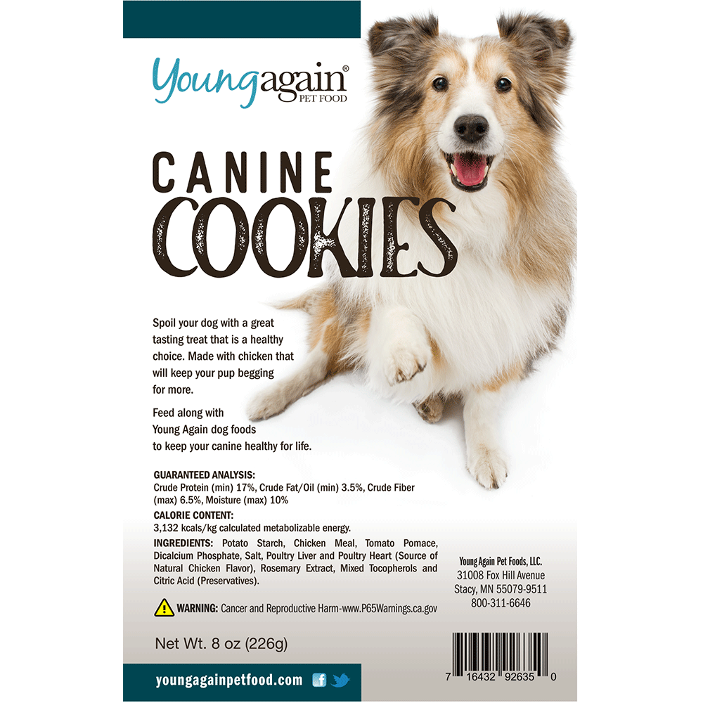 A package of Young Again Pet Food Canine Cookies featuring a happy, fluffy dog. The label highlights healthy ingredients, nutritional information, company details, and a warning about reproductive harm. Net weight: 8 oz (226g).